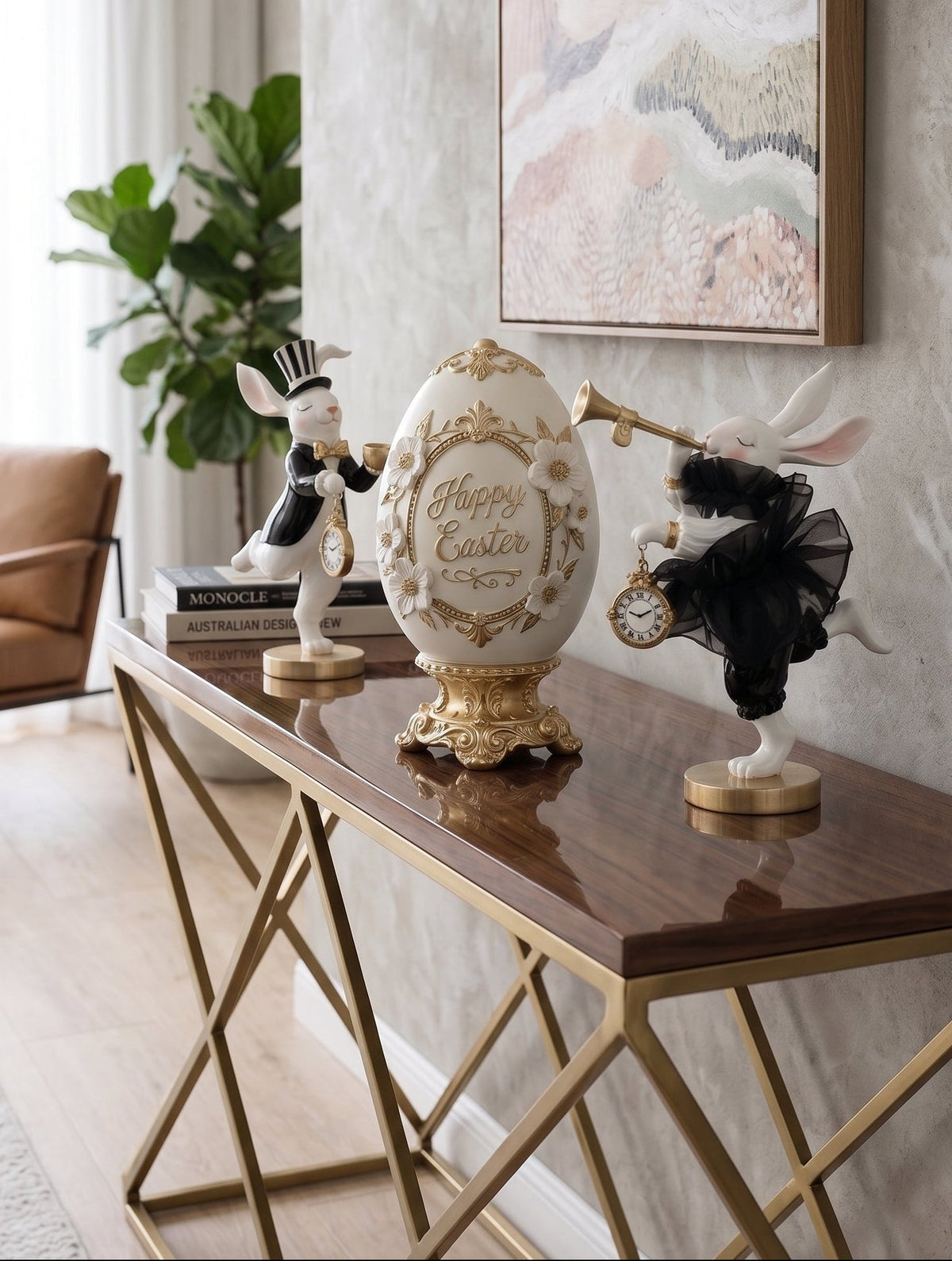 A decorative Easter egg centerpiece with gold floral detailing and 'Happy Easter' text, styled on a dark wood and gold console table in a bright, modern living room.